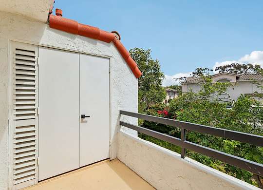 A white door with a red trim is on the side of a building.