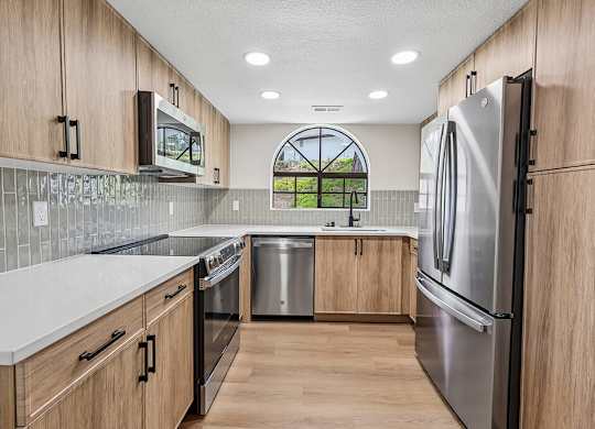 A kitchen with wooden cabinets and stainless steel appliances.