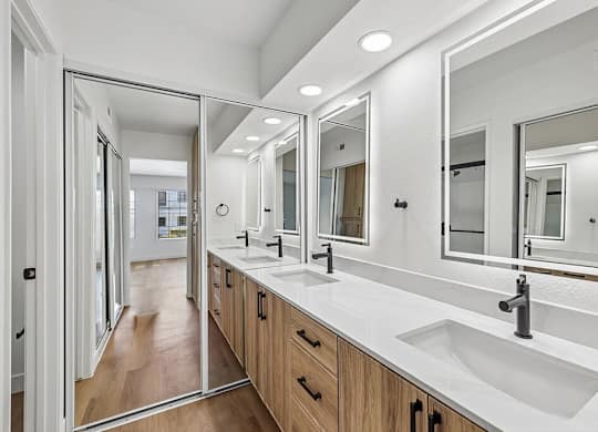 A bathroom with a white counter top and a large mirror.