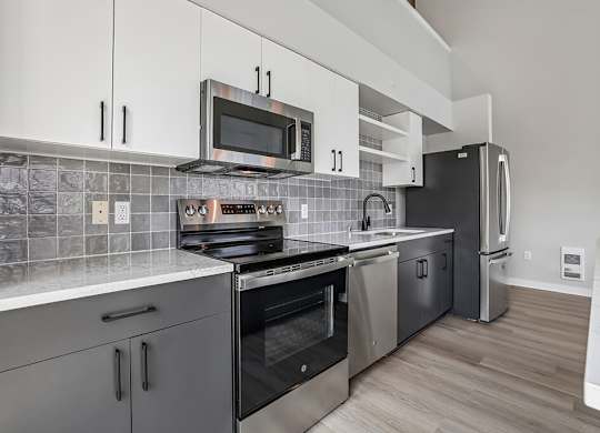 A modern kitchen with a stove top oven and microwave above it.