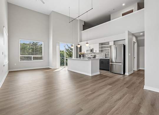 A modern kitchen with a wooden floor and white walls.