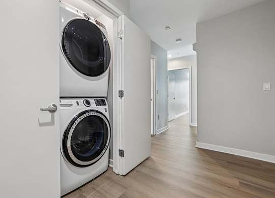 A modern laundry room with a washer and dryer built into the wall.