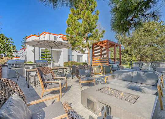 A patio with a table and chairs is surrounded by trees.