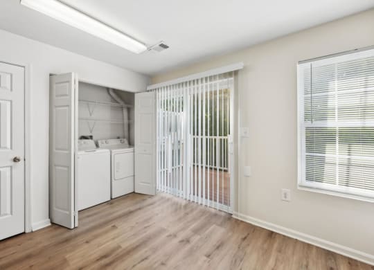 an empty room with a laundry room and a closet