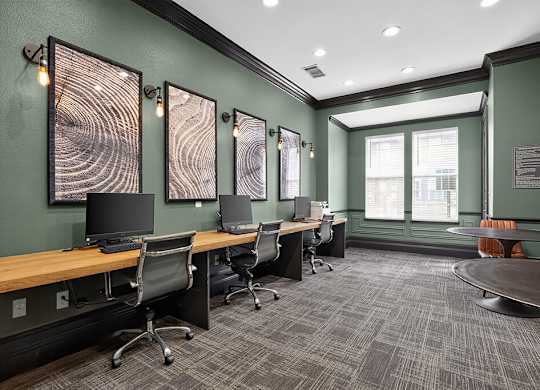 A room with a green wall and a long wooden table with chairs.