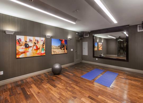 A room with wooden floors and a large mirror on the wall.