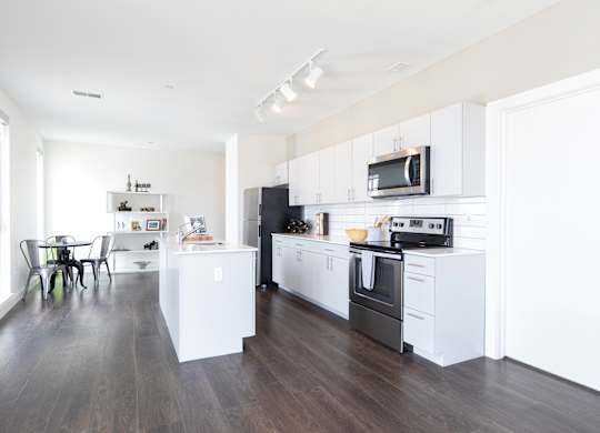 A modern kitchen with white cabinets and appliances.