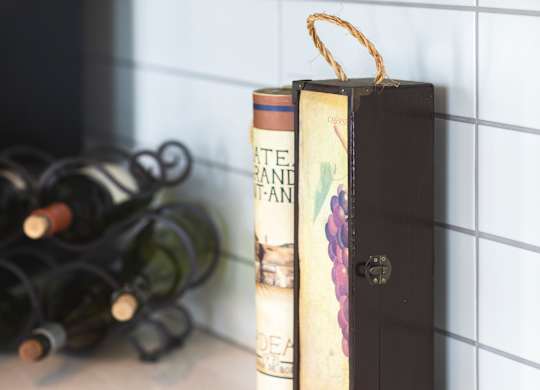 A book with a gold ribbon bookmark sits on a countertop.