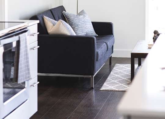 A black couch with pillows sits in a living room.
