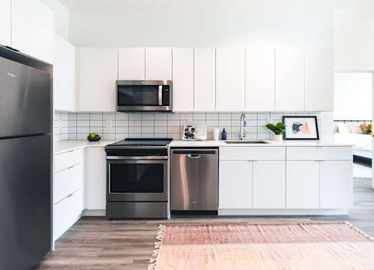 A modern kitchen with a black refrigerator and stainless steel appliances.