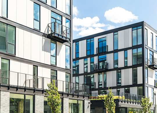 A modern building with balconies and glass windows.