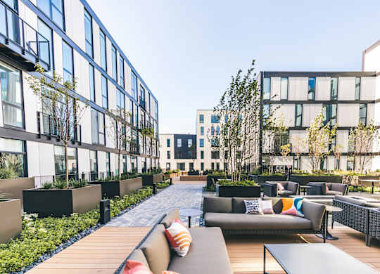 A modern outdoor seating area with couches and tables.
