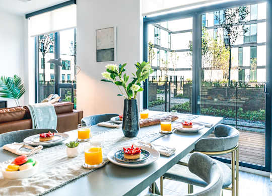 A breakfast table set with plates of food and glasses of orange juice.