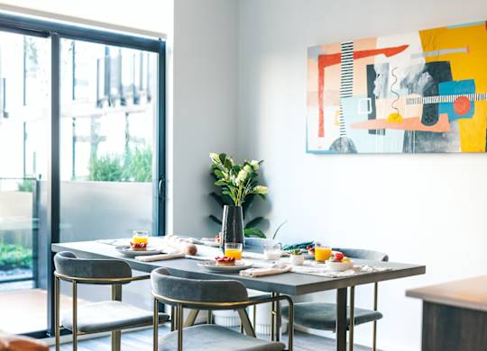 A modern dining room with a table set for four.