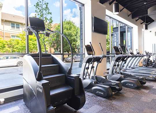 A gym with a variety of cardio equipment including treadmills and elliptical machines.