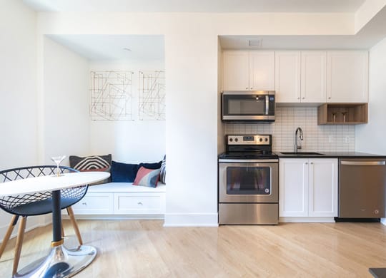 Fully equipped kitchen with stainless steel appliances includes refrigerator, stove, and dishwasher, at The Stott.