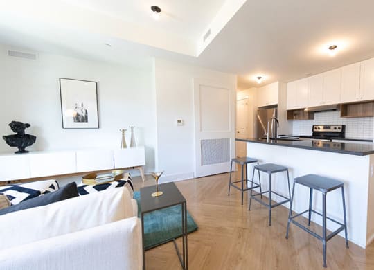 Gourmet kitchen with island, modern appliances, and elegant backsplash at The Stott.