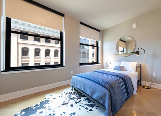 Elegant bedroom with city views at The Stott, Detroit, MI, 48226.