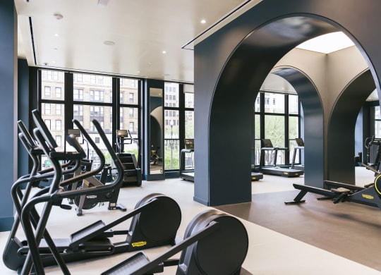 a fitness center with cardio equipment and windows with view of Washington Boulevard at Book Tower, Michigan, 48226