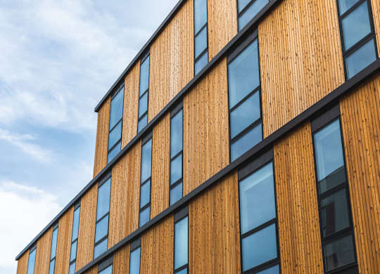 A building with wooden panels and black trimmed windows.