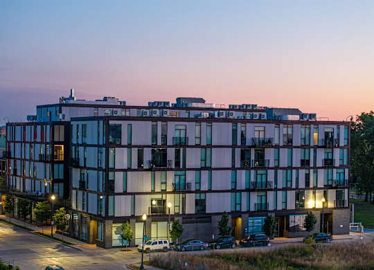 a view of a building at dusk with street lights