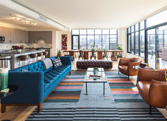 Living Area  with a Blue Couch and Brown Chairs at The Assembly, Detroit, MI