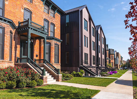 A row of houses with green steps leading to the front door.