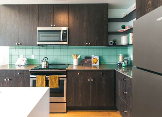 A kitchen with a stove, oven, and refrigerator.