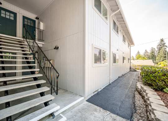 A white building with a black railing staircase.