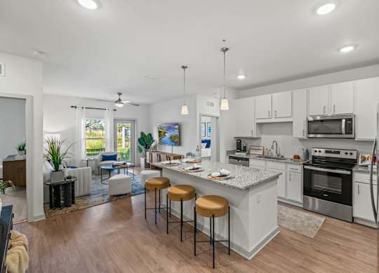 A modern kitchen with a bar area and a dining table.at Altis Grand Lake Willis, Orlando, FL 32821