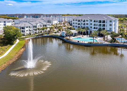 a view of a body of water with a hotel and a fountain at Altis Grand Suncoast, Land O' Lakes