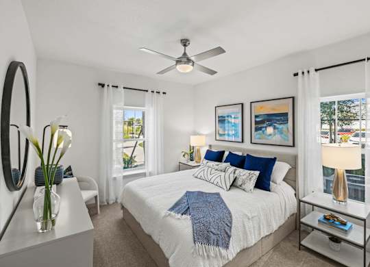 A bedroom with a large bed, a ceiling fan, and a view of the city.at Altis Grand Lake Willis, Orlando, FL