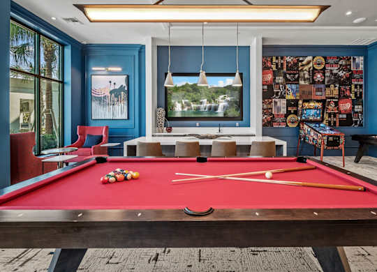 a red pool table in game room with a large window at Altis Twin Lakes Apartments, Florida, 34744
