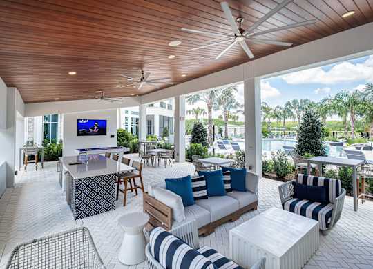A modern outdoor living space with a television and comfortable seating.