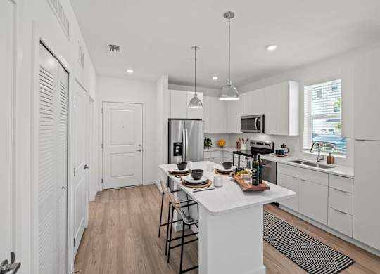 A modern kitchen with white cabinets and a wooden island.