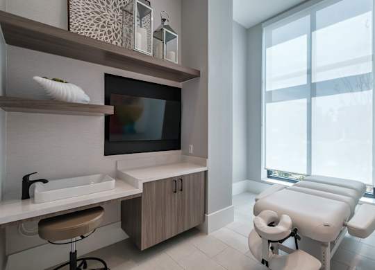 a treatment room at a hospital with a large window and a sink and a chair at Altis Grand Suncoast, Land O' Lakes, FL