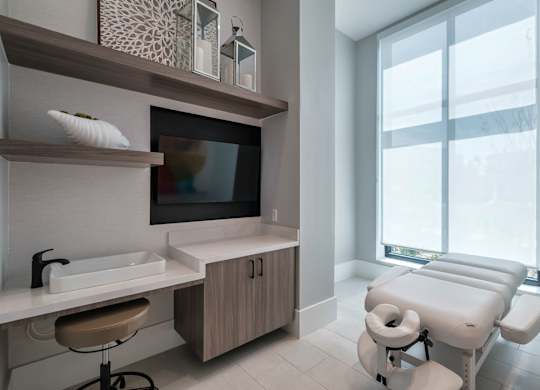 a treatment room at a hospital with a large window and a sink and a chair at Altis Twin Lakes Apartments, Kissimmee