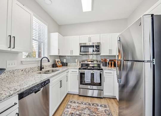 A kitchen with white cabinets and stainless steel appliances.