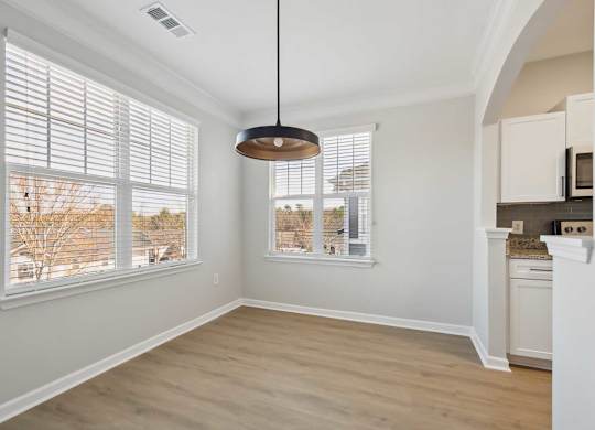 A room with a large window and a hanging light fixture.