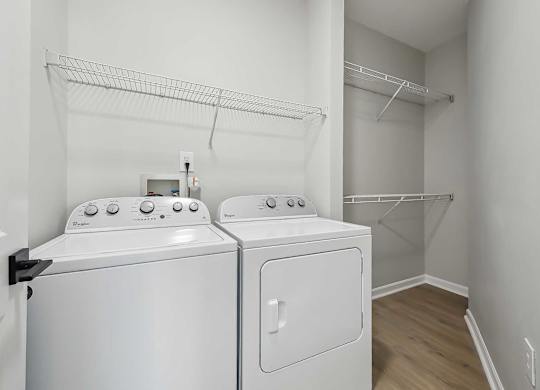 Chapel Hill, NC, Luxury Apartments With In-Unit Washer and Dryer - Reserve at Meadowmont - Laundry Closet with Full-Size Washer, Dryer, and Built-In Wire Racks on the Walls.