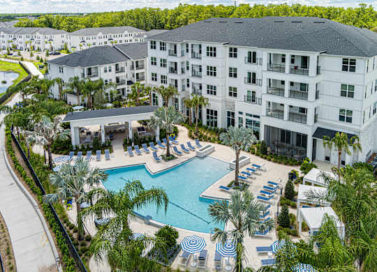 A large white building with a pool in front.