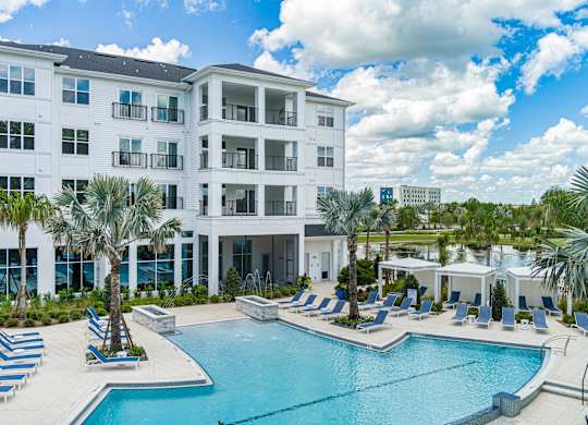 A large white building with a pool in front.
