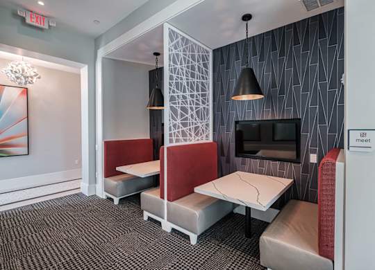 a living room with two tables and chairs and a television at Altis Twin Lakes Apartments, Kissimmee