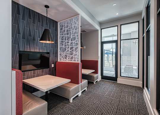 a dining room with tables and chairs and a television at Altis Grand Suncoast, Land O' Lakes, FL