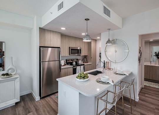 a kitchen with an island and stainless steel appliances at Altis Santa Barbara, Naples, 34104