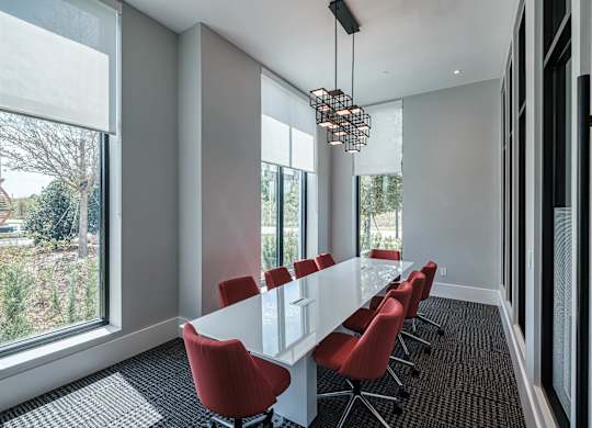a conference room with a long white table and red chairs at Altis Grand Suncoast, Florida, 34638