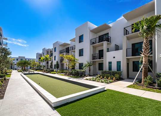 A white building with a green lawn in front.