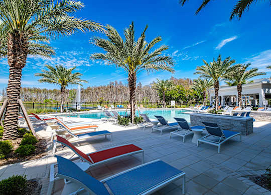 a swimming pool with lounge chairs and palm trees at Altis Grand Suncoast, Land O' Lakes, 34638
