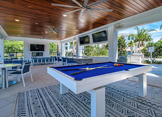 a pool table in a covered patio with tables and chairs at Altis Twin Lakes Apartments, Florida, 34744
