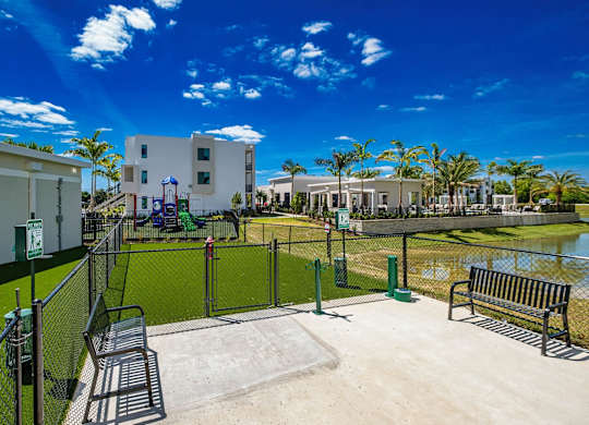 a fenced in area with a tennis court and benches at Altis Santa Barbara, Naples, Florida